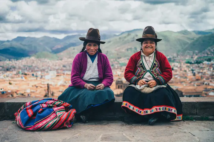 Women in traditional dress, with the city behind them